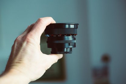 Hand hält Kamera-Objektiv