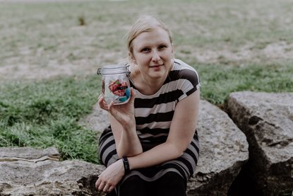 Amelie hält ein Glas mit Müll