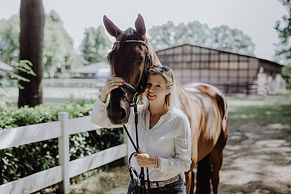 Ina Artig mit einem Pferd auf einem Reiterhof