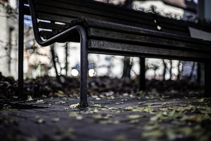 Parkbank im dunklen Licht schafft eine angespannte, gruselige Atmosphäre