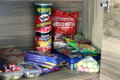 Verschiedene Süßigkeiten und Snacks in einem Schrank