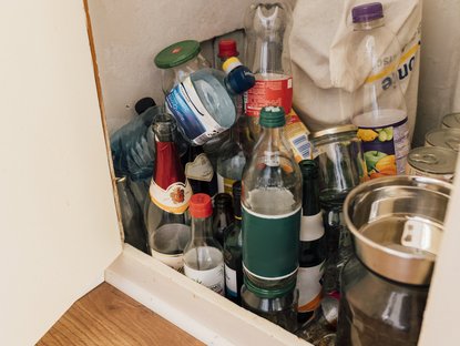 Pfandflschen und Müll in einem Schrank