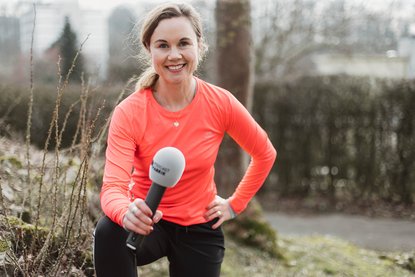 Julia Ures mit dem Mikro der Podcastfabrik in Sportkleidung